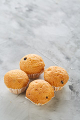 Tasty muffins arranged in pattern on light textured background, close-up, shallow depth of field, selective focus.