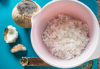 Coconut  and coconut grater on blue color background