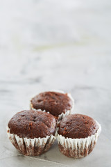 Tasty muffins arranged in pattern on light textured background, close-up, shallow depth of field, selective focus.