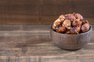 Sugared peanuts on the wooden background