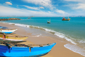Fototapeta na wymiar Fishing boat on the sandy shore against a background the ocean and sky.