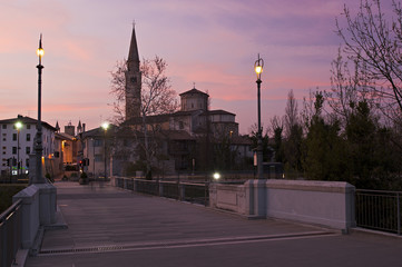 The cathedral of Saint Mark from Adam and Eve Bridge, in Pordenone, at sunset. Italy.