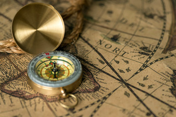 Old compass on vintage map with rope