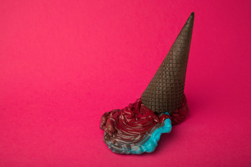 plastic ice cream blue and red in chocolate black cone on pink p