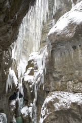 Fototapeta na wymiar Frozen waterfall with icicles seen in the park