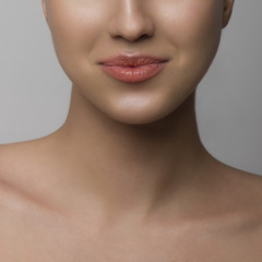 Fototapeta premium Close up of dissatisfied lips. The young woman with pure leather squeezes lips, a grin with natural gloss on lips
