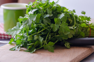 Preparing to eat fresh parsley on a wooden board.