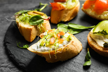 Delicious bruschettas served on slate plate, closeup