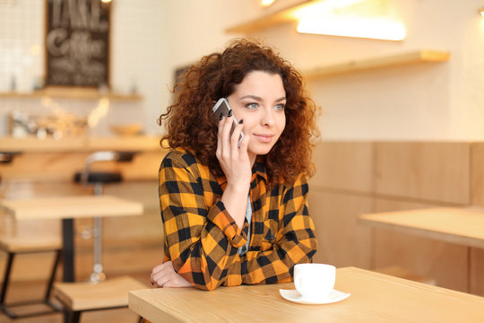 Young woman talking on mobile phone indoors