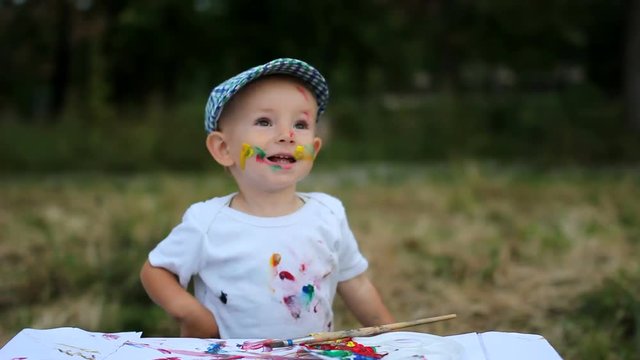 Adorable baby child, smile, laugh happy to paint in nature, feel free to create