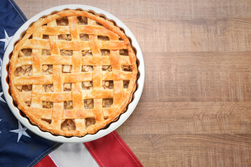 Delicious American apple pie with flag on table