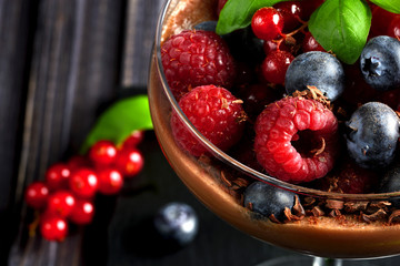 Ideas for a healthy diet. Dietary Chocolate mousse, parfait with fresh berries of raspberries, blueberries and red currants in a glass goblet