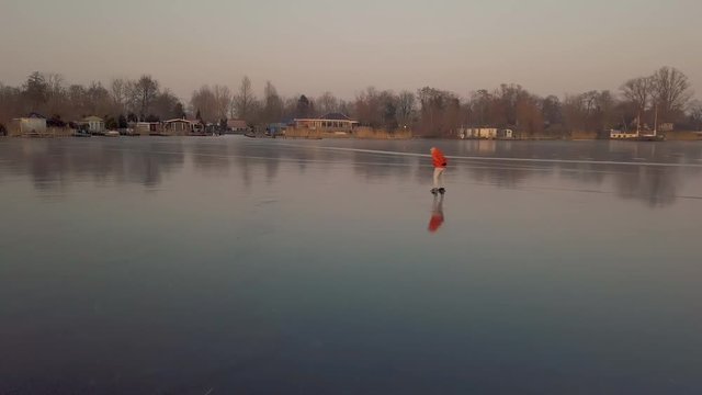 A man is skates on a natural frozen lake in the Netherlands.