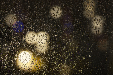 drops of rain on the window on the background of the night bokeh