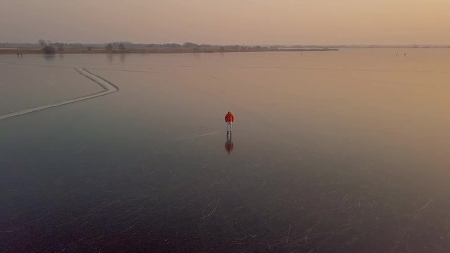 A man is skates on a natural frozen lake in the Netherlands.