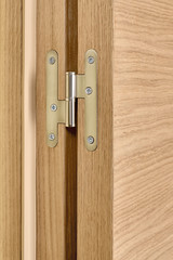 Obraz premium Closeup of metal hinges on light brown wooden doors