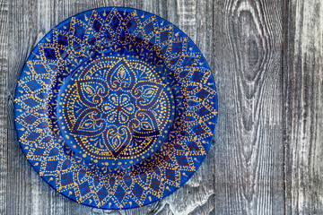 Top view blue hand-painted plate on wooden surface