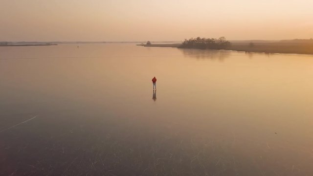 A man is skates on a natural frozen lake in the Netherlands.