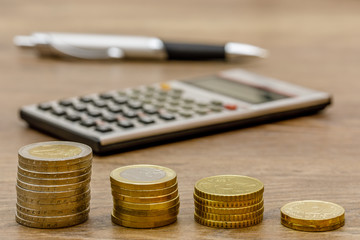 Münzstapel mit Taschenrechner und Kugelschreiber - Konzept Planung