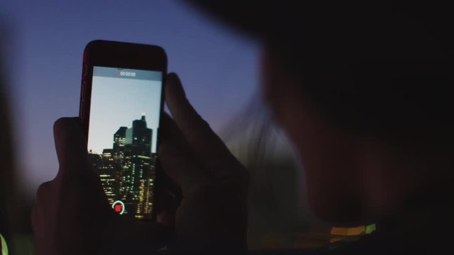 Silhouette Of Tourist Taking Video Of Manhattan Skyline At Dusk