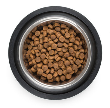 Stainless steel metal bowl for dog, cat or other pet with dried food isolated on a white background, top view.