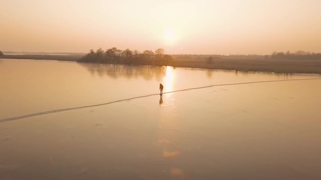 A man is skates on a natural frozen lake in the Netherlands.