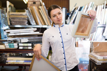 Glad woman is standing with modern pictures