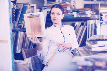 Young woman is standing with modern pictures