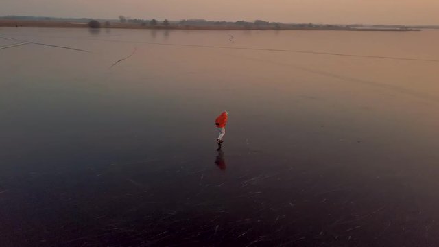 A man is skates on a natural frozen lake in the Netherlands.
