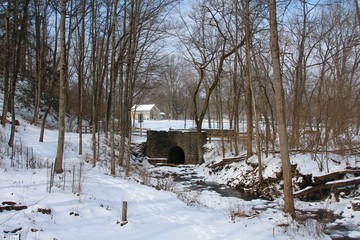 The stone bridge and the snowy park landscape.
