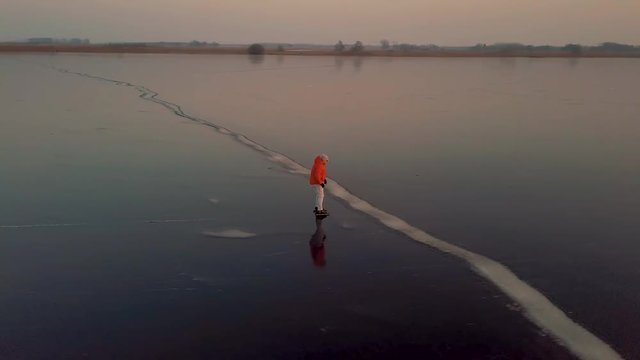 A man is skates on a natural frozen lake in the Netherlands.