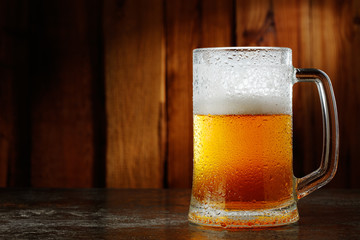 mug with beer on a wooden background