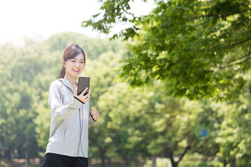 公園でジョギングするスポーティーな女性
