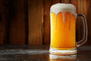 mug with beer on a wooden background