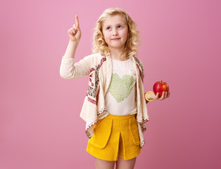 child isolated on pink background with an apple got an idea