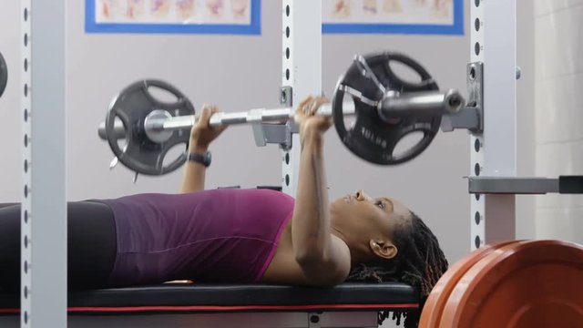 Young black woman working out on a bench press