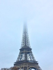Eiffel Tower tip covered in fog during new years day in Paris