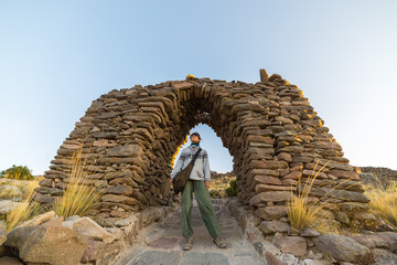 Tourist exploring Inca trails at sunset on Amantani' Island, Titicaca Lake, among the most scenic...