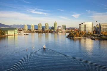 Fototapeten Boats and paddleboarders in False Creek, Vancouver with views of Science World and Olympic Village © photogenio