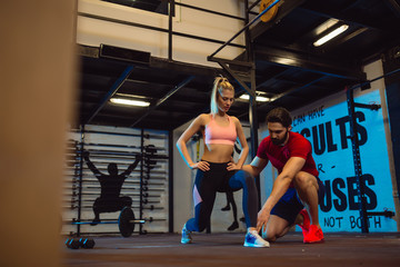 Young attractive woman doing exercises with personal trainer.