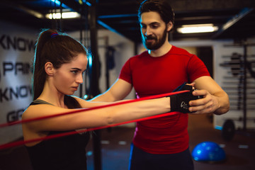 Side view of a beautiful girl doing fitness exercises in gym.