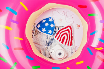 Inflatable donut float, American flag crochet bikini, camera and shorts. Summer vacation holiday concept