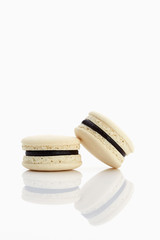 Assorted macaroons over white background with reflection.
