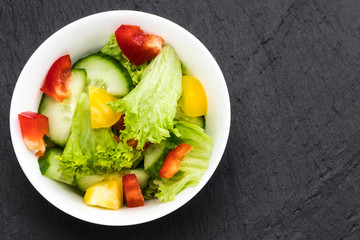 Fresh vegetable salad on balck background. top view, copy space