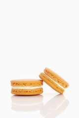 Assorted macaroons over white background with reflection.