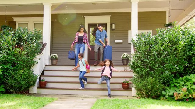 Family With Luggage Leaving House For Vacation