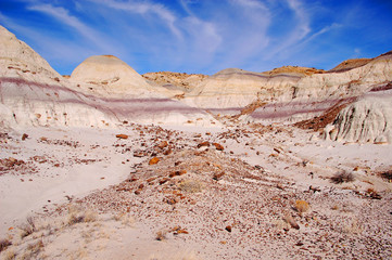 Vista of rocky lonesome badlands with wispy clouds in bright blue sky in the Bisti De Na Zin wilderness in Northern New Mexico