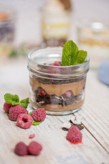 Chocolate cheese dessert with cherries, raspberries, blueberries on a wooden table