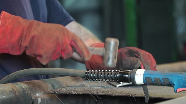 industrial factory.Little iron hammer and steel forms for stamping. Clip. Welder workshop table at factory. Professional tools for metal production. Small hammer. Detail shot of hammer forging hot