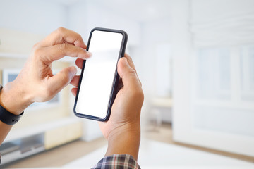 Male hand holding smartphone at office. Blank screen mobile phone for graphic display montage